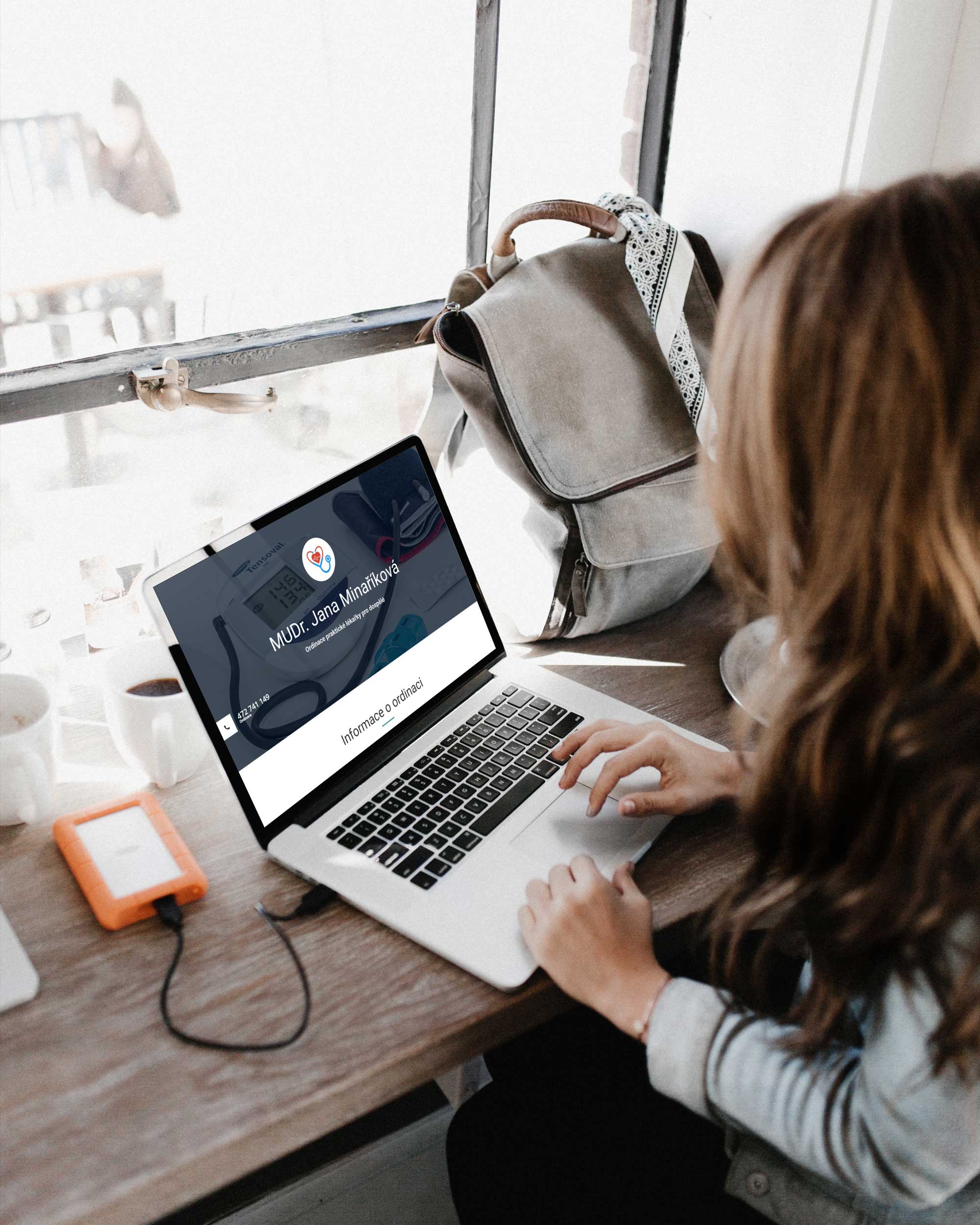 Laptop položený na stole s microsite MUDr Minaříkové